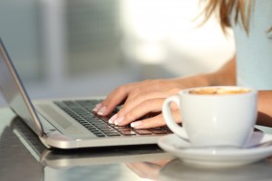 Close up of a woman hands typing in a laptop in a coffee shop terrace in the street ** Note: Shallow depth of field