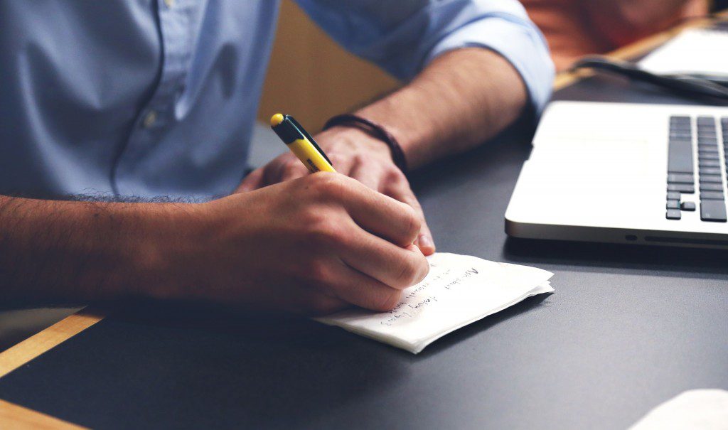 Man holding yellow pen