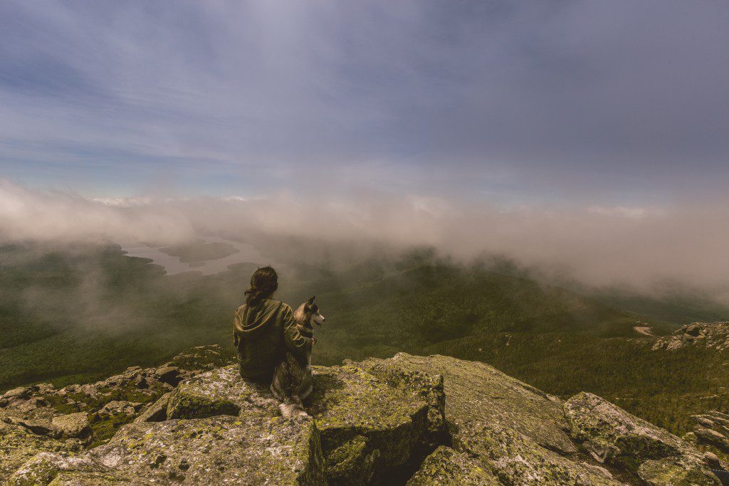 A woman sitting on a rock asking herself, Why Get an MBA?