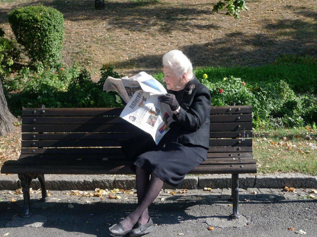 A man reading a newspaper at the ted rogers school