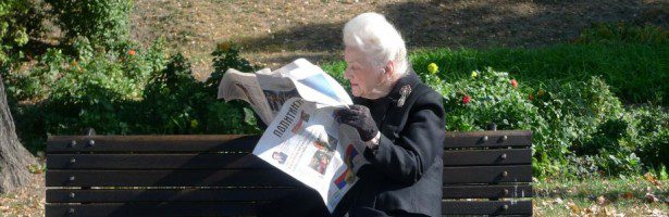 A man reading a newspaper at the ted rogers school